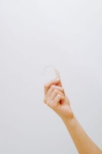 Hand holding a clear aligner used to correct an overbite in Thornhill